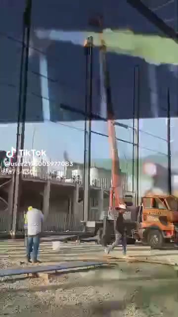 فيديو قصير لرافعة سلة مركبة على شاحنة ممدودة بجانب هيكل حديدي في موقع إنشاء
